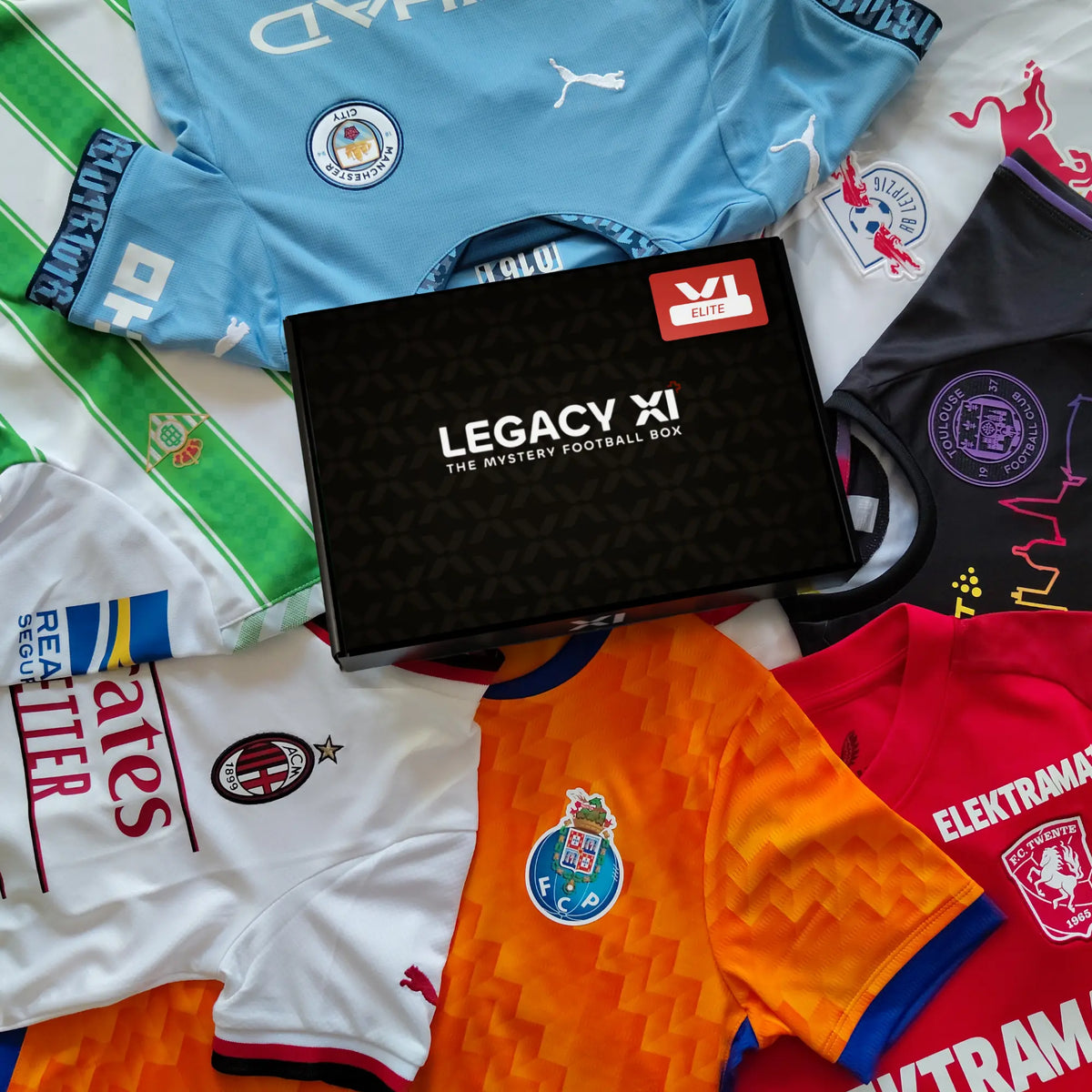 Boîte mystère maillot de football enfant Legacy XI Elite entourée de maillots officiels de clubs européens.