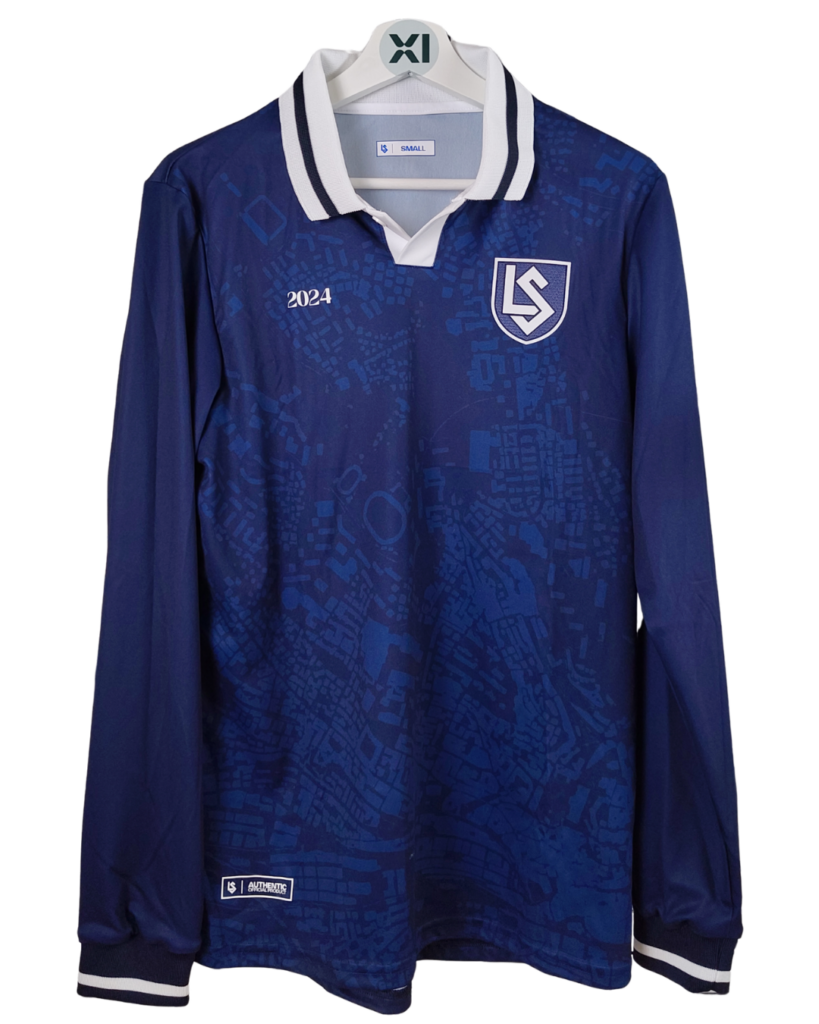 Troisième maillot de football à manches longues du Lausanne-Sport pour la saison 2024-25, de couleur bleu marine avec un motif graphique ton sur ton et un col polo blanc. Le blason du club et l'année '2024' sont visibles sur la poitrine.
