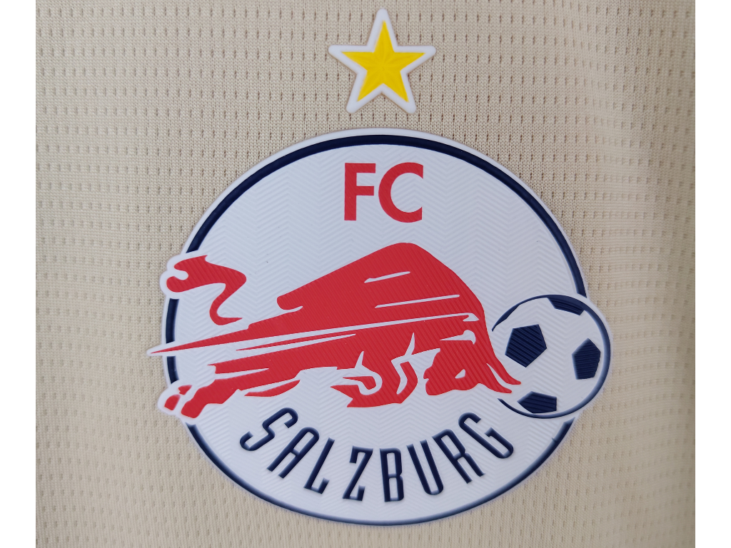 FC Salzburg football club crest with a red charging bull, a soccer ball, a star above, on a circular white background